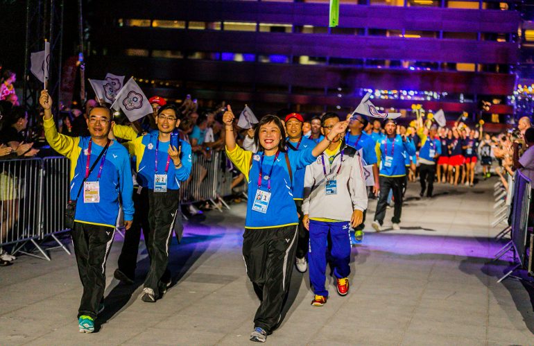 Photo of atheletes walking through crowd