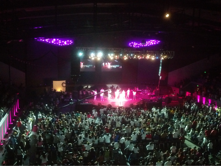 Photo of people performing on stage in front of crowd